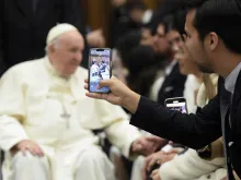 مؤمن يلتقط صورة البابا فرنسيس في قاعة بولس السادس-الفاتيكان