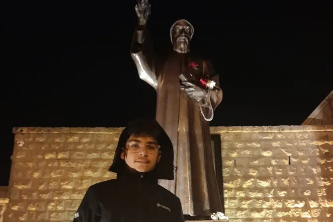 جوفن بدران يقف أمام تمثال القديس شربل في عنّايا