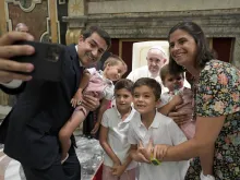 رجل يلتقط صورة لعائلته مع البابا فرنسيس في خلال مقابلة خاصّة معه في أغسطس/آب الماضي