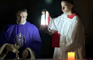 الأب يوسف أسعد يحتفل بالذبيحة الإلهيّة في رعيّة العائلة المقدّسة-غزّة على ضوء مصباح كهربائيّ مصدر الصورة: جبرائيل رومانيلّي