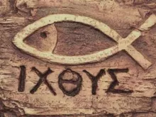 حفر على قطعة خشبيّة لرمز السمكة مع الأحرف الأولى لعبارة «يسوع المسيح المخلّص ابن الله»