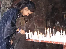 فتاة صغيرة تضيء شمعة في مغارة ماريان في باكستان