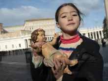 طفلة تحمل تمثال الطفل يسوع في ساحة القديس بطرس الفاتيكانيّة