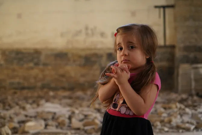 طفلة مسيحيّة وهي تردّد صلاة على أنقاض كنيسة مسكينتا المدمّرة في الموصل