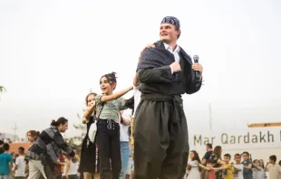 أليكس مكينا يحتفل مع تلاميذ مدرسة مار قرداغ بالملابس التراثيّة السريانيّة مصدر الصورة: صفحة مدرسة مار قرداغ في فيسبوك