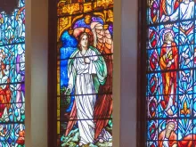 نافذة من الزجاج المعشّق المزدان بصور مقدّسة في إحدى الكنائس