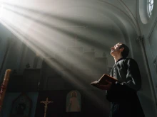 صورة تمثّل كاهنًا يصلّي في الكنيسة