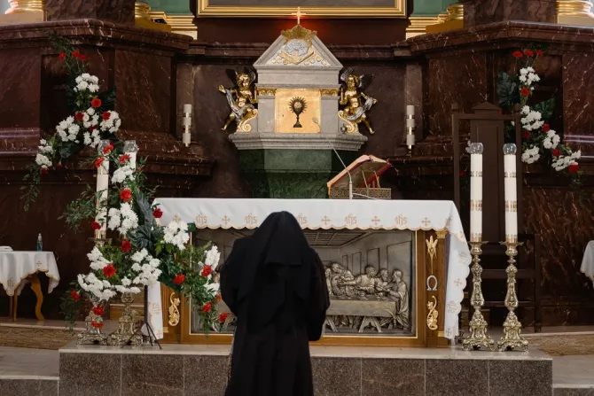 صورة تعبيريّة تمثّل راهبة ترفع الصلاة في الكنيسة