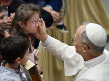 البابا لاوون الرابع عشر يبارك طفلة في خلال لقاء احتضنته قاعة بولس السادس جمعه بالعاملين في حاضرة الفاتيكان وعائلاتهم (24 مايو/أيّار 2025)