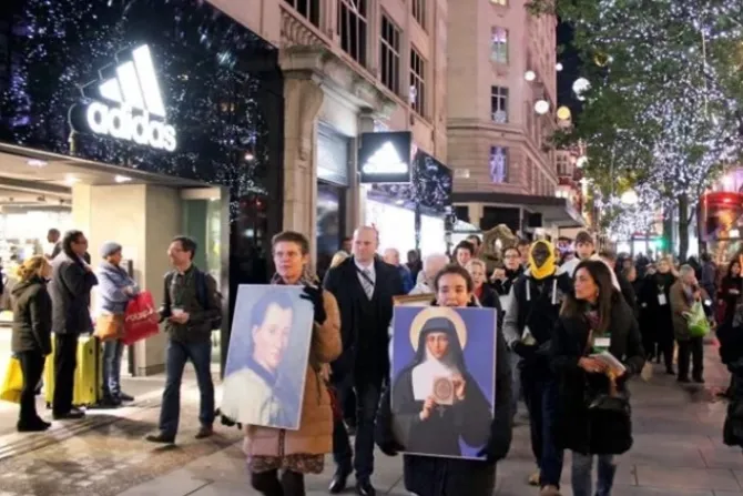 مؤمنون يسيرون في زيّاح في أحد شوارع لندن حاملين صورتي القديس كلود والقديسة مارغريت ماري ألاكوك
